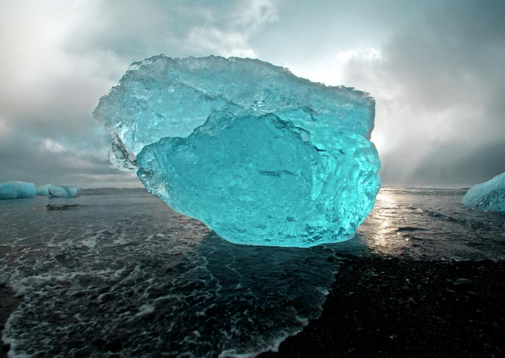 Amazing Blue Iceberg washed up on the volcanic beaches of Iceland
